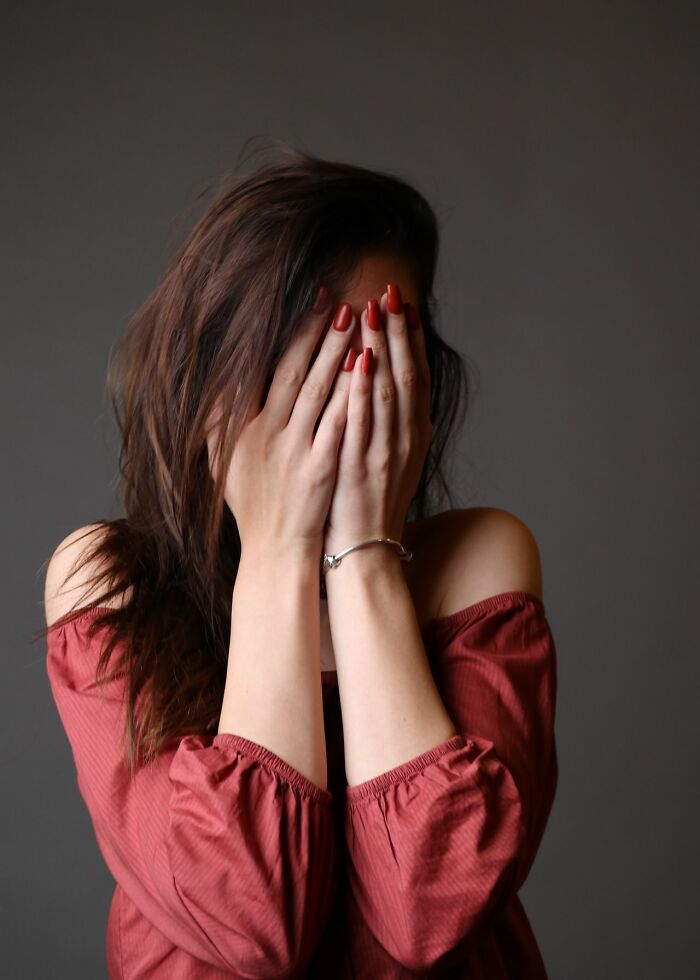 A woman covering her face, illustrating people's instincts to get away from creeps.