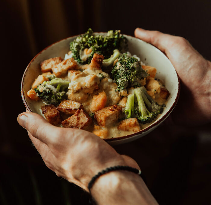 Hands holding a bowl of healthy meal, a popular trendy snack food choice among Americans.