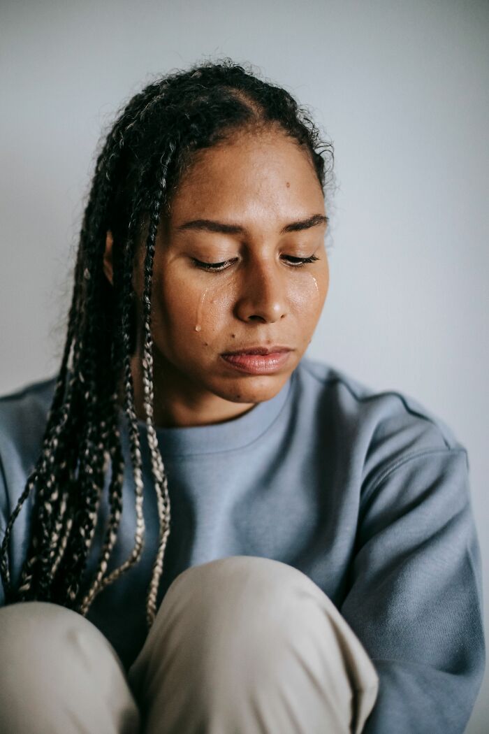 A woman crying with tears, showing the emotional impact of discovering cheating red flags.