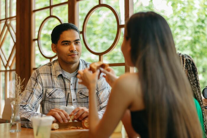A man listens intently to a woman, considering his past baby talk. She once thought he was perfect.