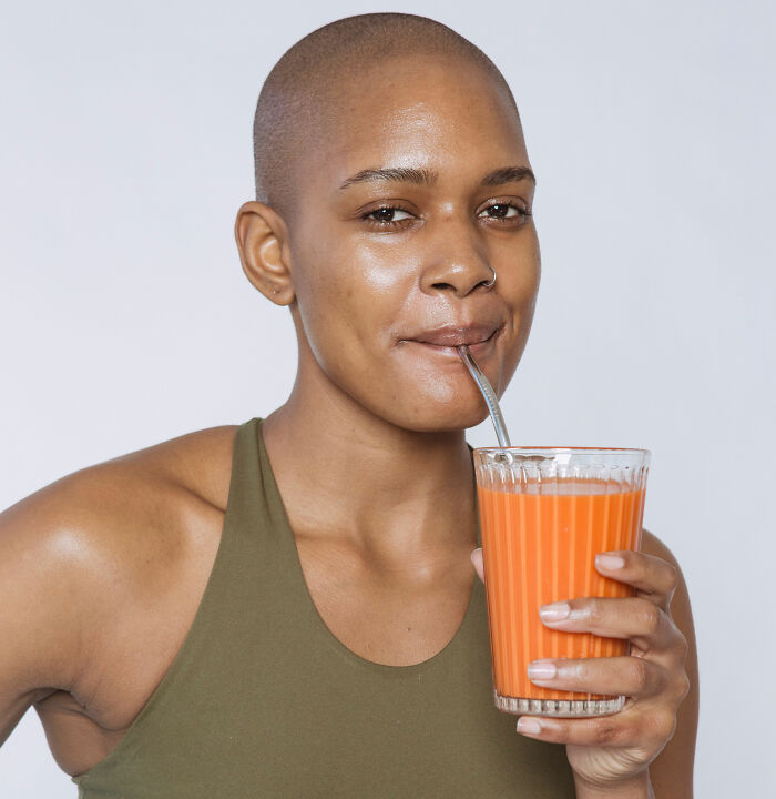 A woman drinking a trendy snack food smoothie with potential terrifying side effects.