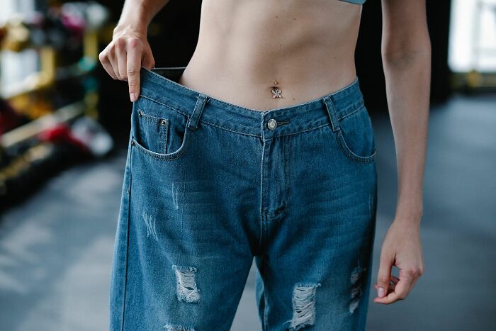 A person showing loose jeans around their waist, a random thing people tried for their health and it actually worked.