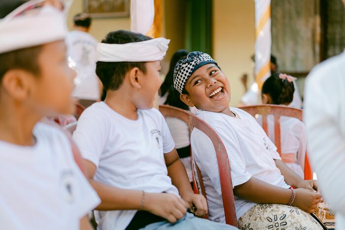 Joyful kids laughing together in a group, experiencing new versions of normal at a friend's house.