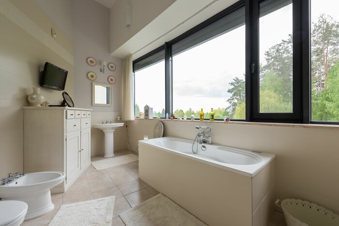 A spacious modern bathroom with a large window, suggesting different normal family home amenities for kids visiting.