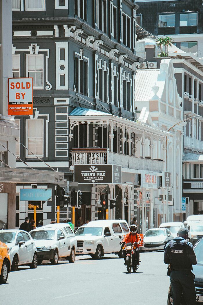 A bustling city street with cars and pedestrians, reflecting misunderstandings between locals and foreigners.