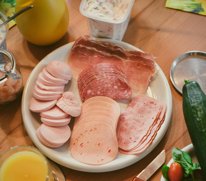 A plate filled with various deli meats and cheeses, alongside other food items, symbolizing snack food.