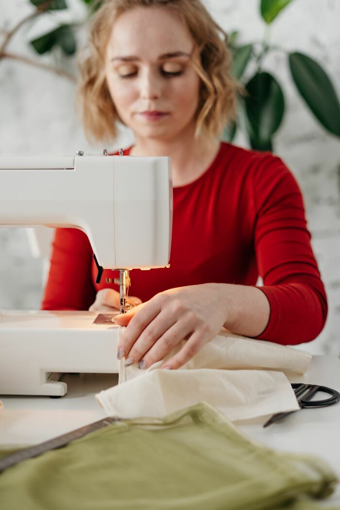A woman sewing, a calm activity contrasting with the drama of entitled friends.