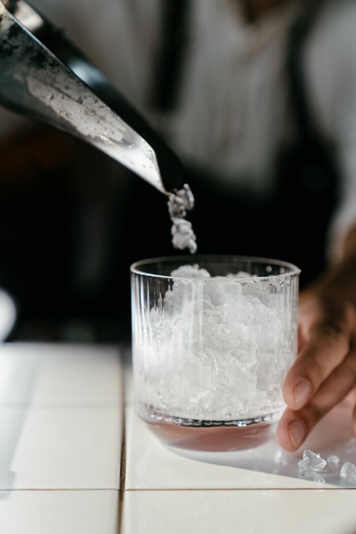 Crushed ice being scooped into a glass, illustrating a specific American habit.