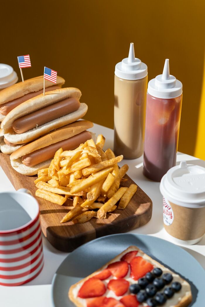 Hot dogs and French fries with small American flags, representing American habits and food.