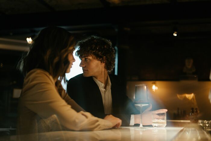 A couple at a bar, looking at each other while discussing why women changed minds about guys they once thought were perfect.