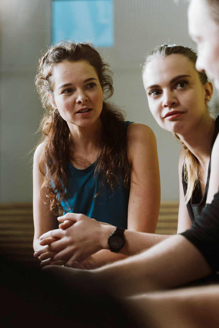 Three women engaged in a conversation, analyzing psychological red flags in relationships.