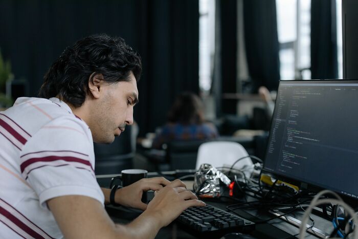 Man typing on a computer, revealing industry secrets about tech jobs and programming.