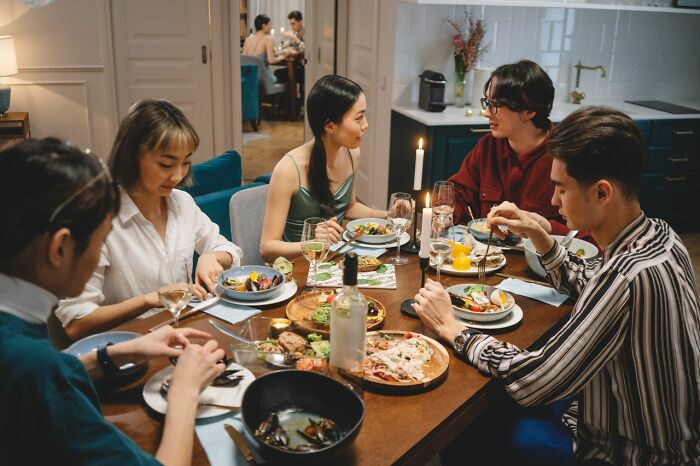 Friends dining together, one possibly exhibiting behaviors of entitled friends.