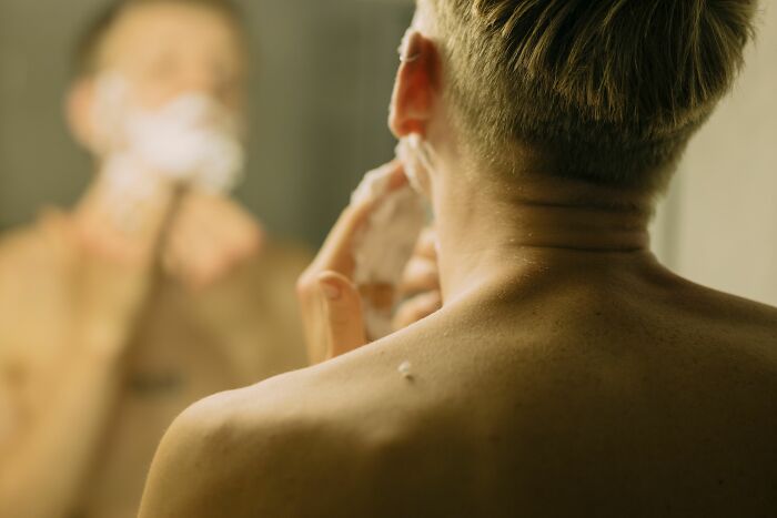 A man shaves, indicating self-grooming that could be a cheating red flag.