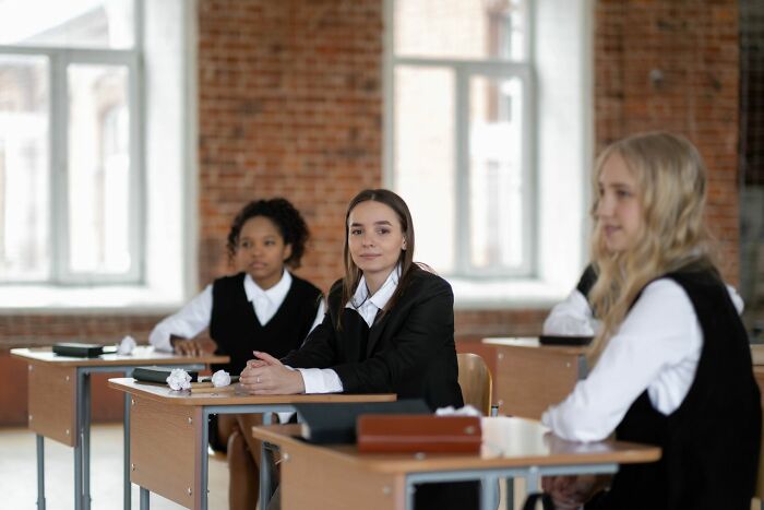 Students in a classroom, one looking at the camera, thinking about the rarest things that have happened to them.