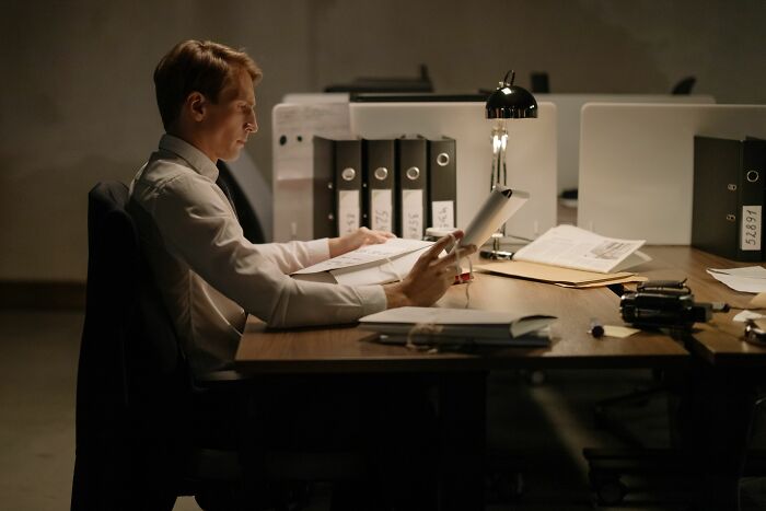 A man working late in an office, reflecting on a crazy office story from his final day at work.