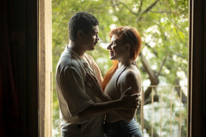 A couple looking at each other affectionately by a window, a contrast to public horror stories.