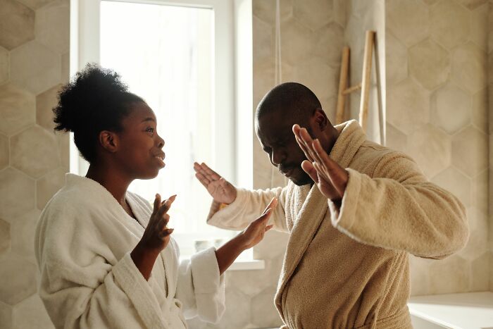 A couple arguing in bathrobes, showing small cheating red flags.