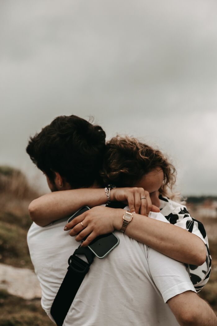 A couple embraces outdoors, showing support through life-changing unexpected twists and turns.
