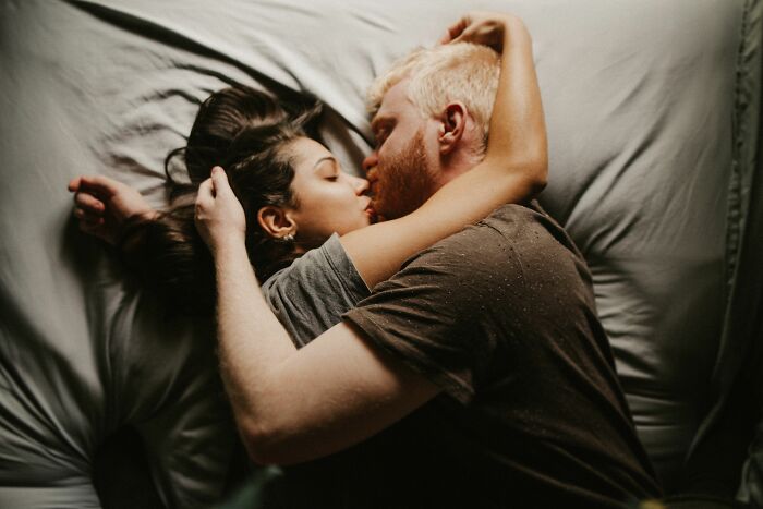 A couple embracing in bed, illustrating a version of normal a kid might observe at a friend's house.