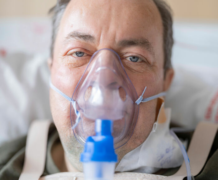 Close-up of a patient wearing an oxygen mask, indicating severe pneumonia symptoms. Close-up of a patient wearing an oxygen mask, indicating severe pneumonia symptoms.