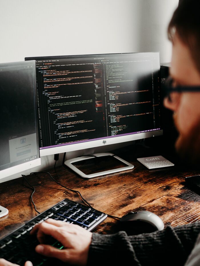 A programmer coding on a computer, revealing industry secrets about software development jobs.