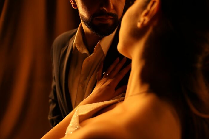 A close-up of a couple, with the woman's hand on the man's chest, hinting at intimate secrets.