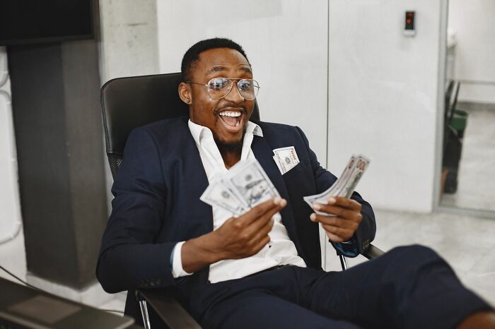 An excited man in glasses and a suit holds money, representing the humor in 'white phrases' and common expressions.