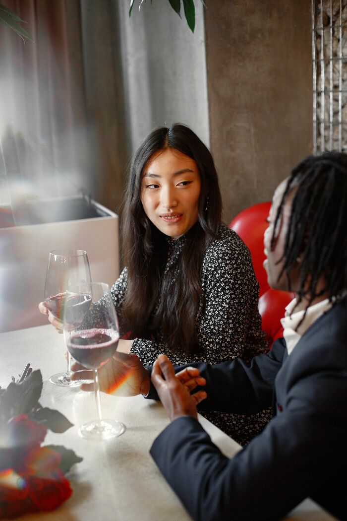 A woman talks with a man, once thought perfect, over wine. She is having baby talk, considering her decision.