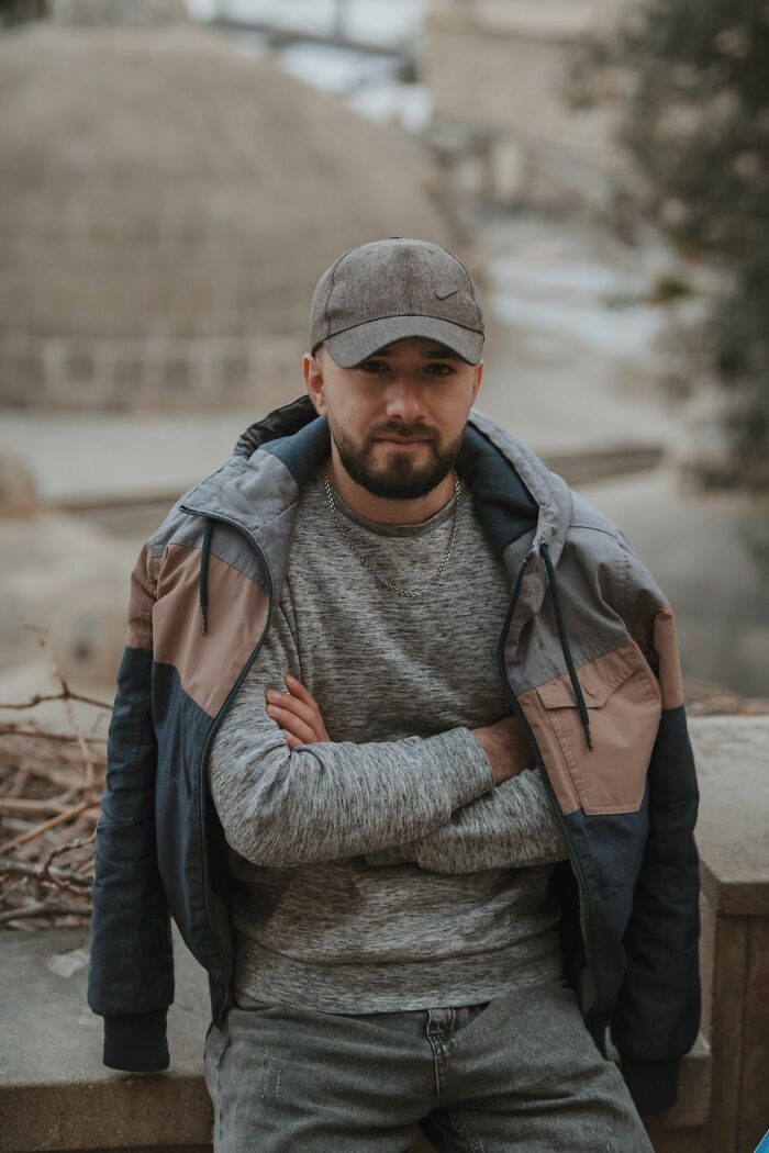 A man in a cap and jacket with crossed arms, looking like people's instincts tell them to get away from creeps.