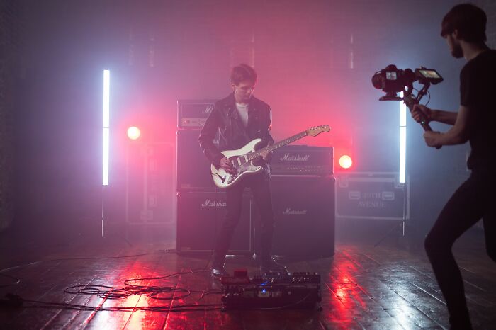 A musician playing an electric guitar, performing opening lyrics from the '70s & '80s with a band and recording A musician playing an electric guitar, performing opening lyrics from the '70s & '80s with a band and recording