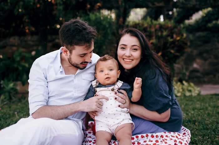 A happy family with a baby, enjoying a rare family moment outdoors.