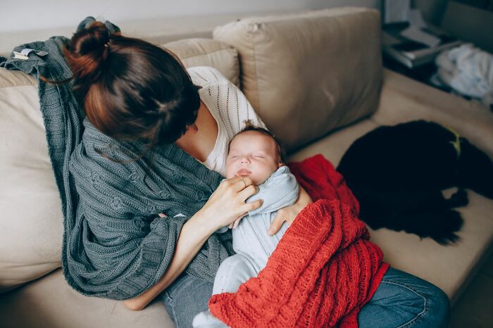 A mother cradling a sleeping baby, representing aspects of American habits.