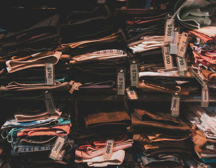 A pile of clothes for sale with price tags. This image relates to clothing sizes and challenges peoples beliefs about them. A pile of clothes for sale with price tags. This image relates to clothing sizes and challenges peoples beliefs about them.