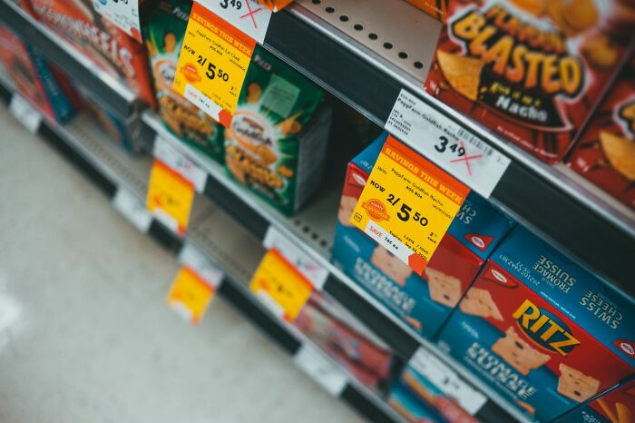 Grocery store shelves with items and sale tags, illustrating American habits of shopping and discounts.