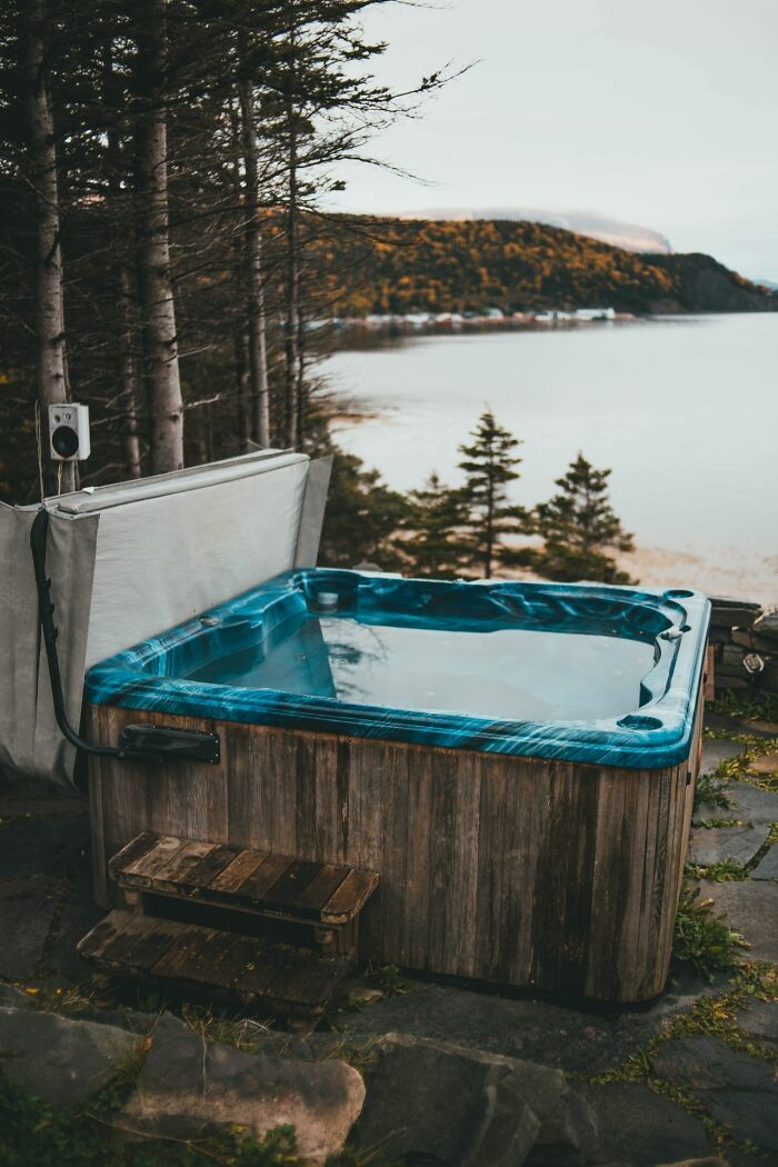 A hot tub with a view of a lake and autumn trees, a relaxing escape from entitled friends.