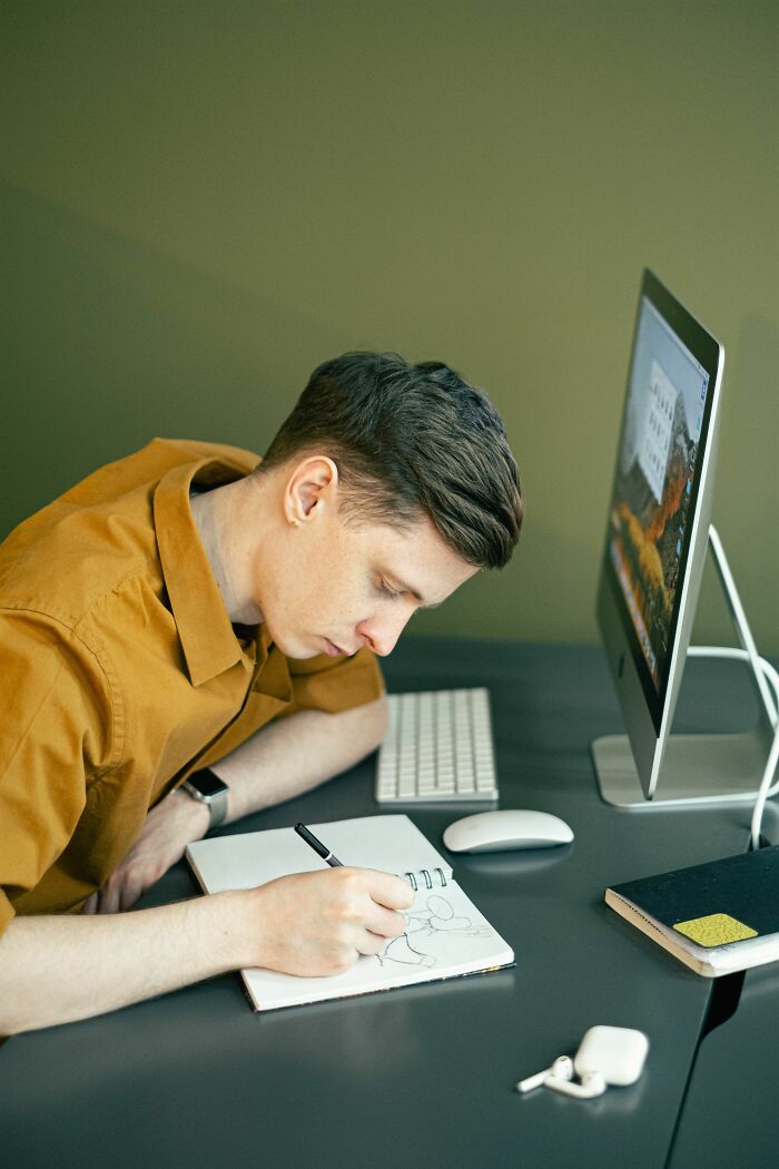 A man drawing in a notebook, possibly showing entitled friends true colors.