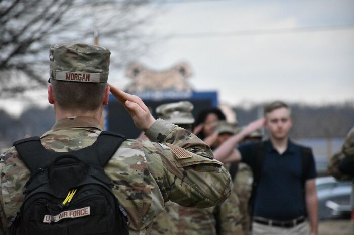 A man in military fatigues saluting, representing secrets people weren't supposed to know.