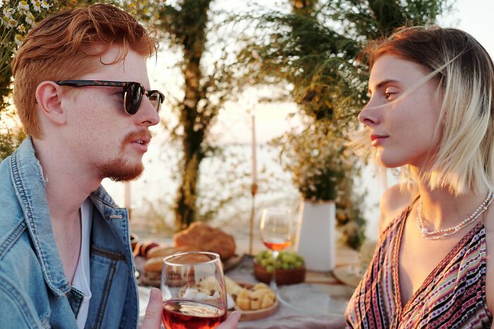 A couple enjoying wine and food outdoors, discussing why women changed minds about guys they once thought were perfect.