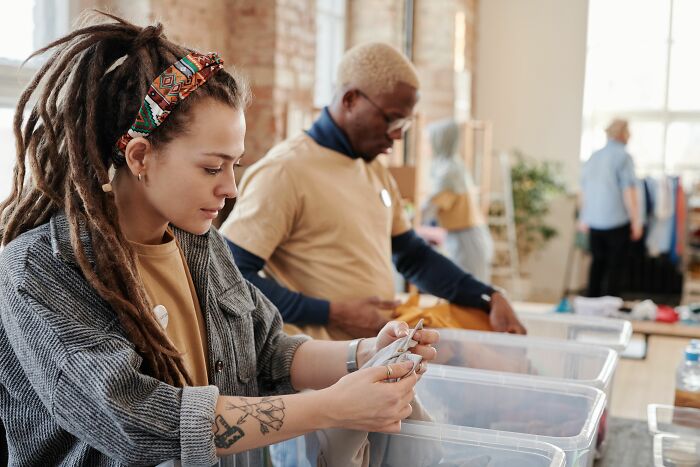 Volunteers sorting items, subtly hinting at overlooked psychological red flags in community interactions.
