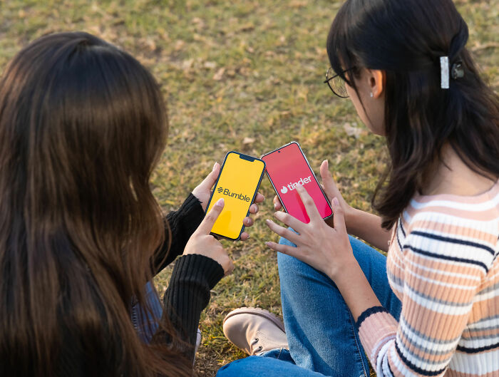 Two women hold phones showing Bumble and Tinder apps, representing modern dating platforms and challenges like voice memo ultimatums. Two women hold phones showing Bumble and Tinder apps, representing modern dating platforms and challenges like voice memo ultimatums.