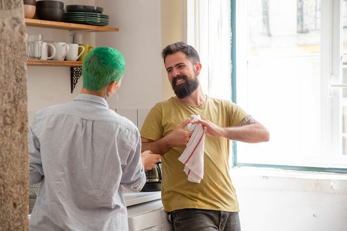 A couple smiling in the kitchen, discussing things everyone should know before getting married.
