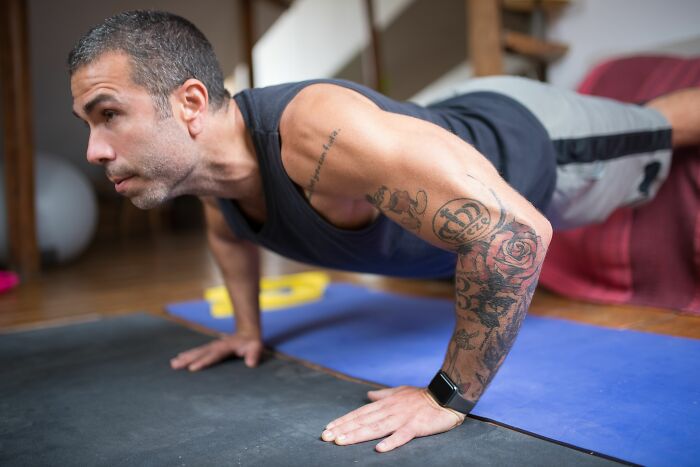 A man doing push-ups, potentially a sign of increased self-care as a cheating red flag.