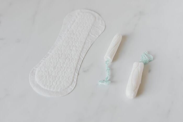 Sanitary pads and tampons on a marble surface, representing a family's version of normal for kids.