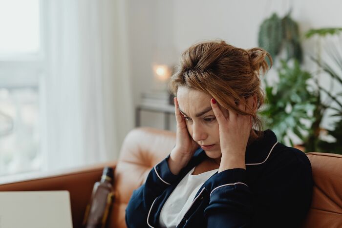 A woman looking stressed and holding her head, illustrating the unexpected twists and turns in people's lives.