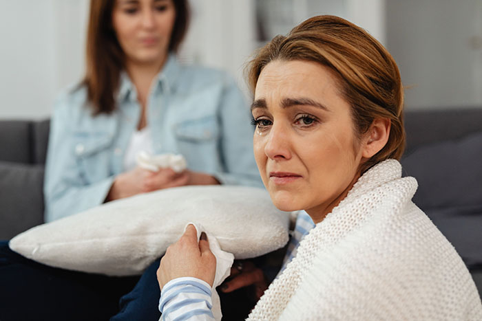 A woman crying, feeling like the third wheel in her own marriage, with her MIL as part of the problem. A woman crying, feeling like the third wheel in her own marriage, with her MIL as part of the problem.