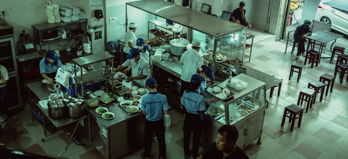 A busy restaurant kitchen with many chefs, reflecting health inspections and the importance of a vegetarian diet.