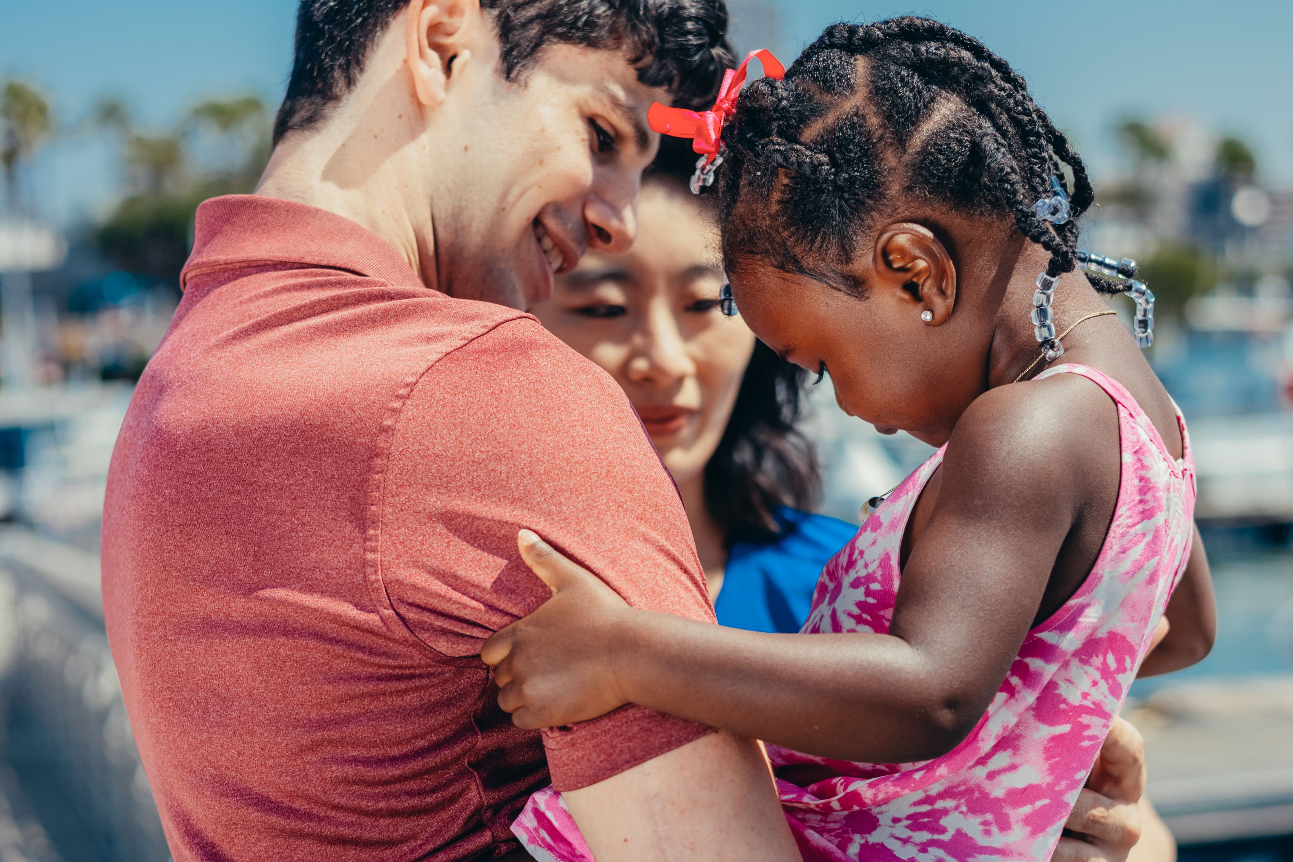A man smiles while holding his young stepson, with a woman behind them, in a scene unrelated to the Old Karen accusation. A man smiles while holding his young stepson, with a woman behind them, in a scene unrelated to the Old Karen accusation.