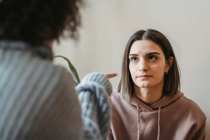 A woman looking intently at someone off-camera, potentially sensing psychological red flags in a conversation.