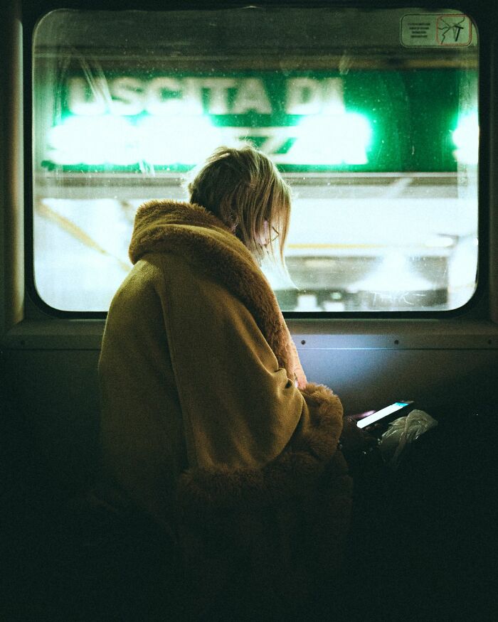 A person in a fur-lined coat looks at a phone on a train, sensing deeply evil creeps.